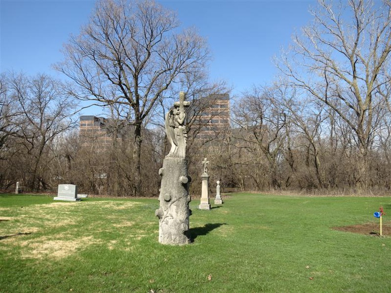 All_Saints_Parish_Cemetery_Chicago_IL_April_22_2013_sandstone_angel_hugging_cross.jpg
